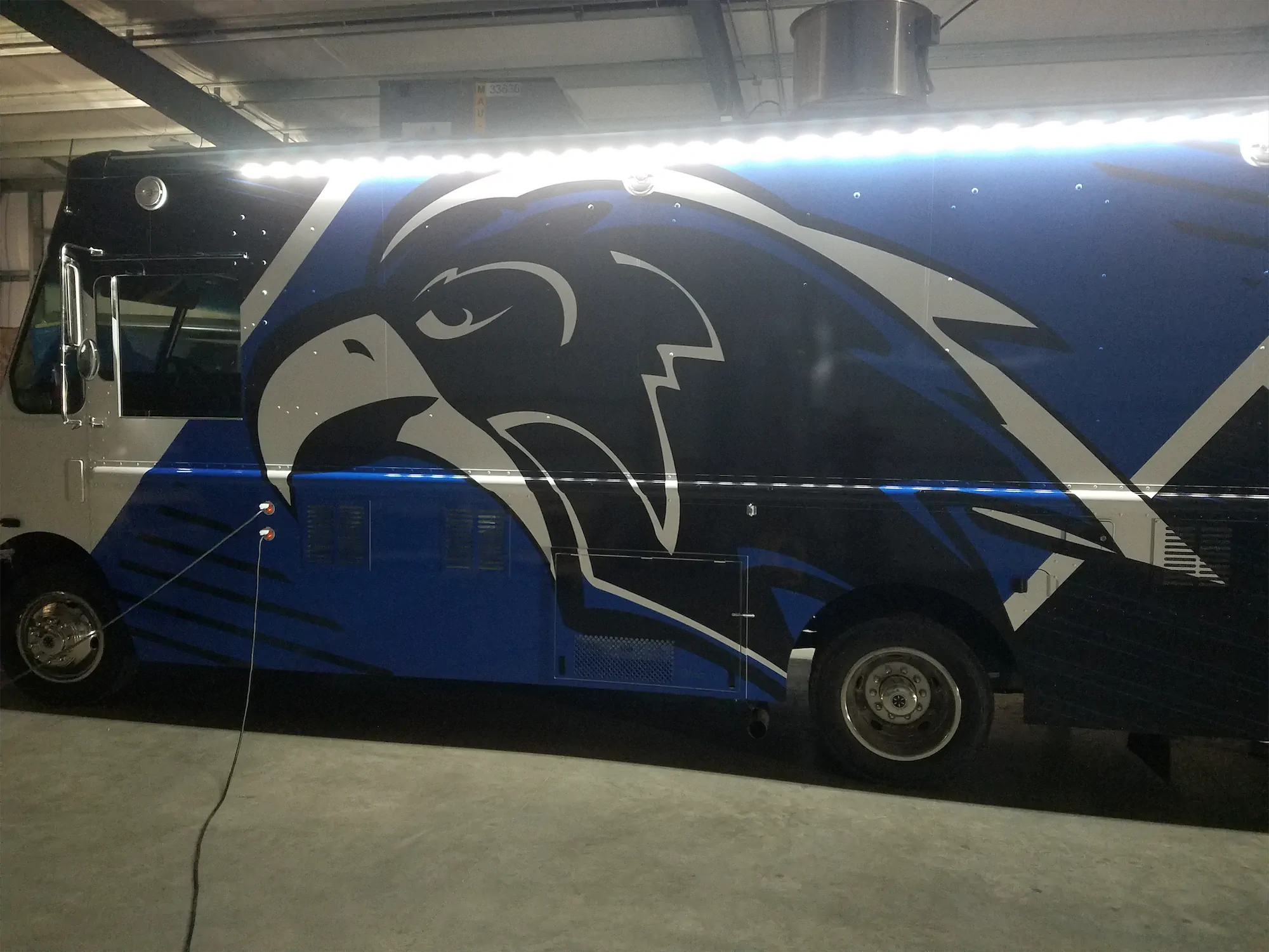 Falcon Pride truck, outside, left side looking at the falcon logo with the truck lights on