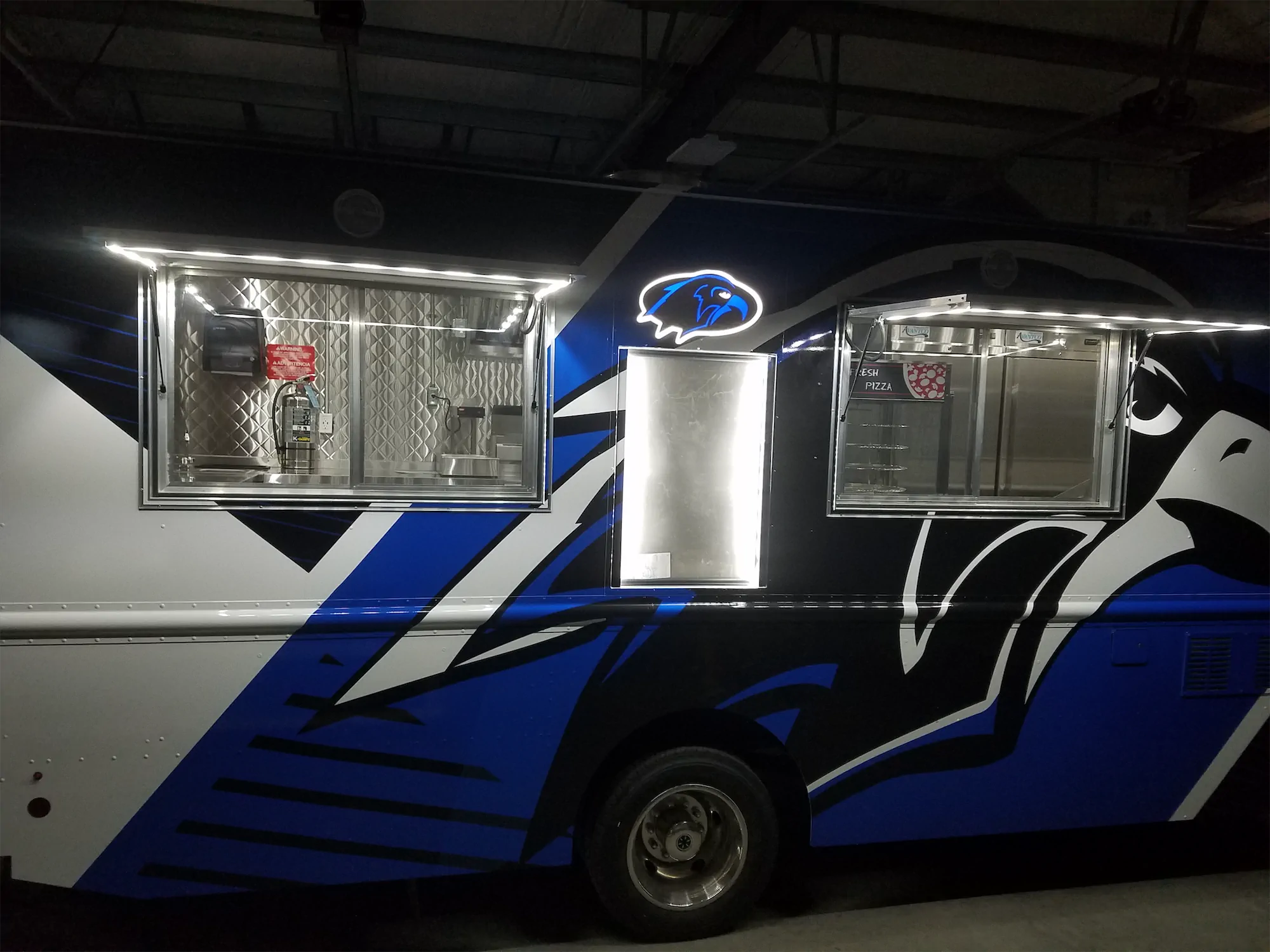 Falcon Pride truck, outside, right side windows open with overhead lights on