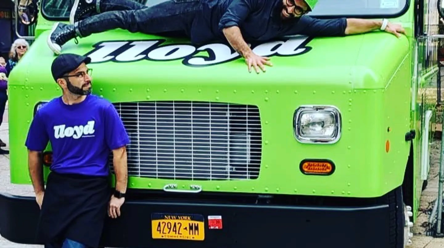 Lloyd Taco truck number 5 with the owners hanging out by the front of the truck