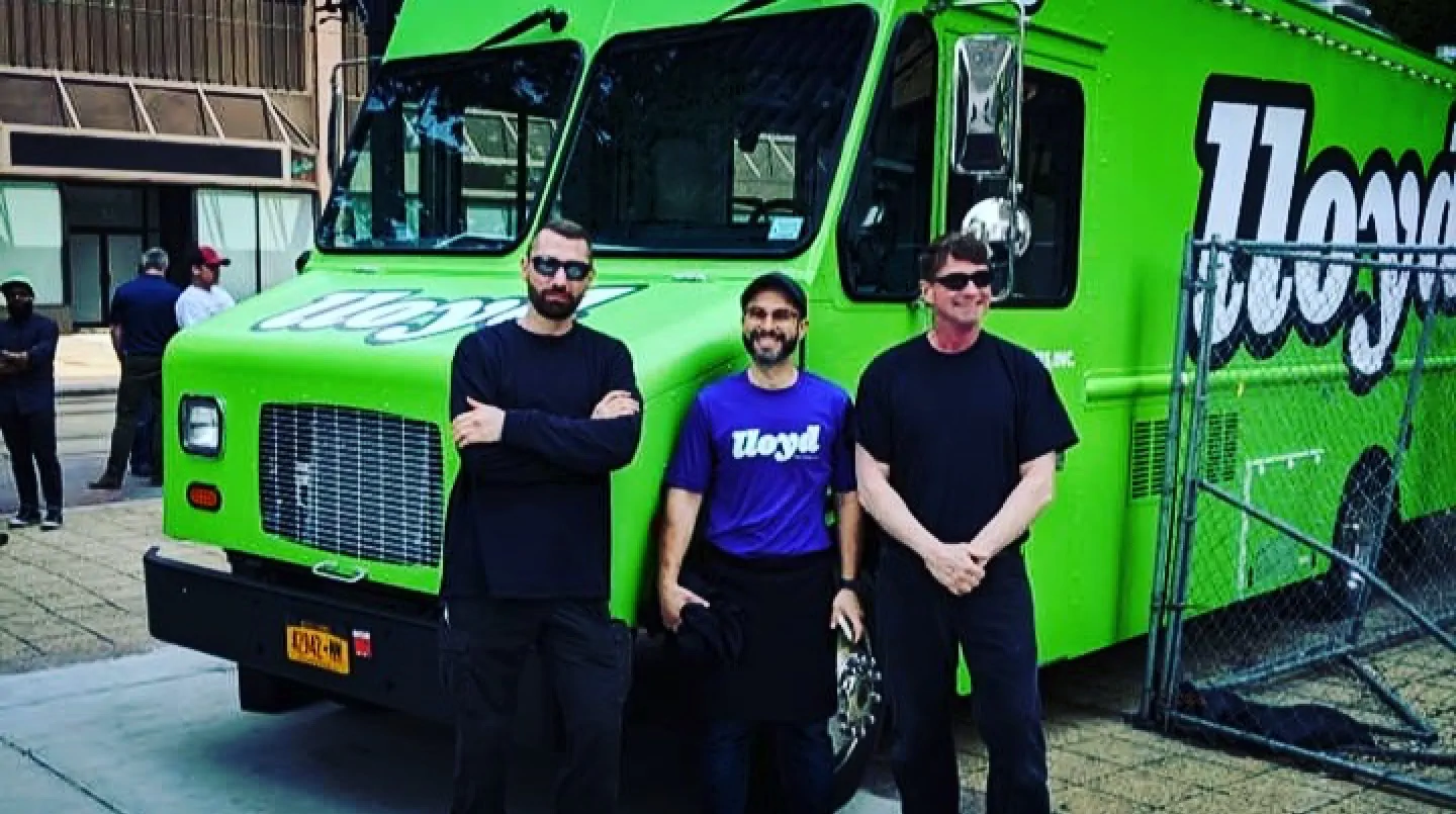 Lloyd Taco truck number 5 with the owner and members of the JP team hanging out by the front of the truck