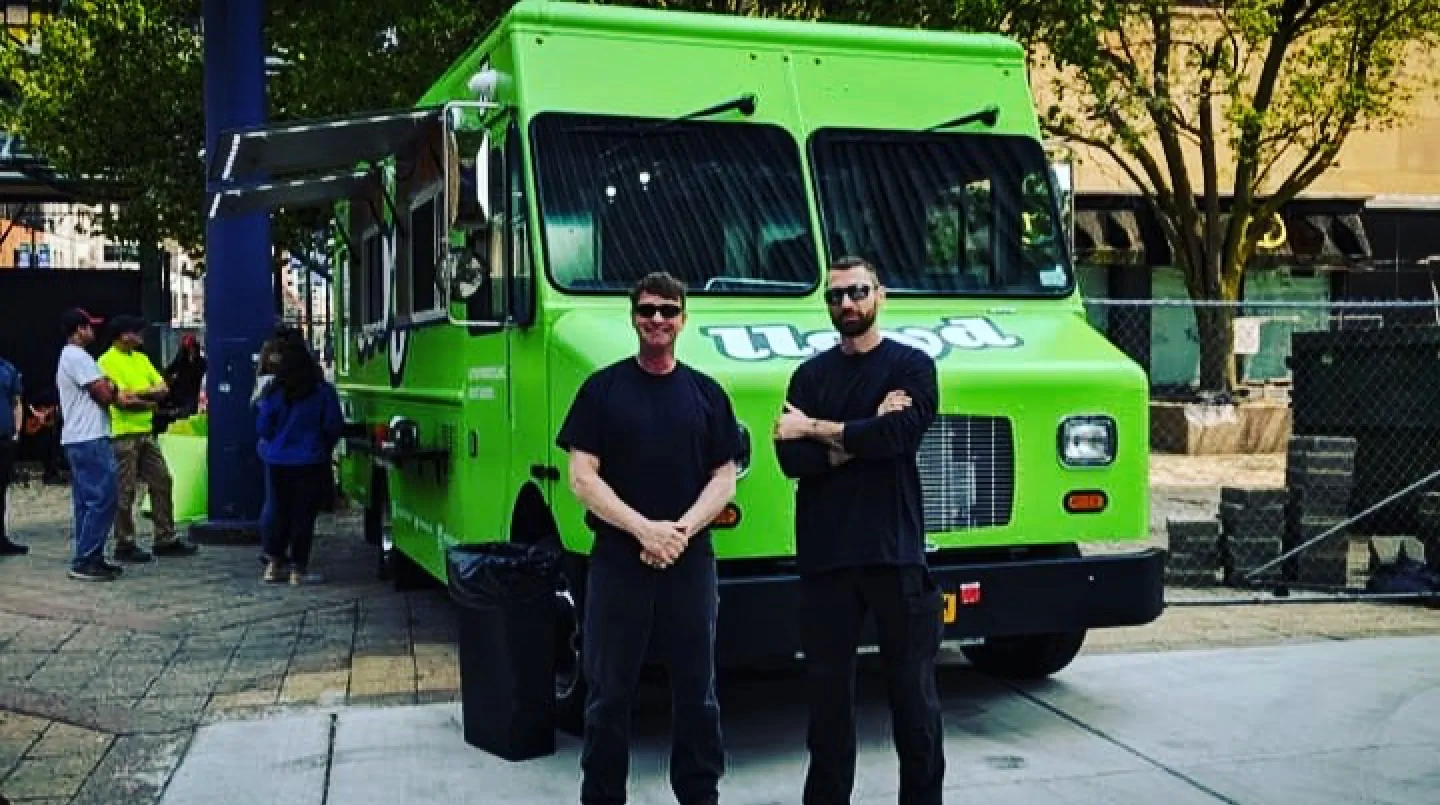 Lloyd Taco truck number 5 with members of the JP team hanging out by the front of the truck